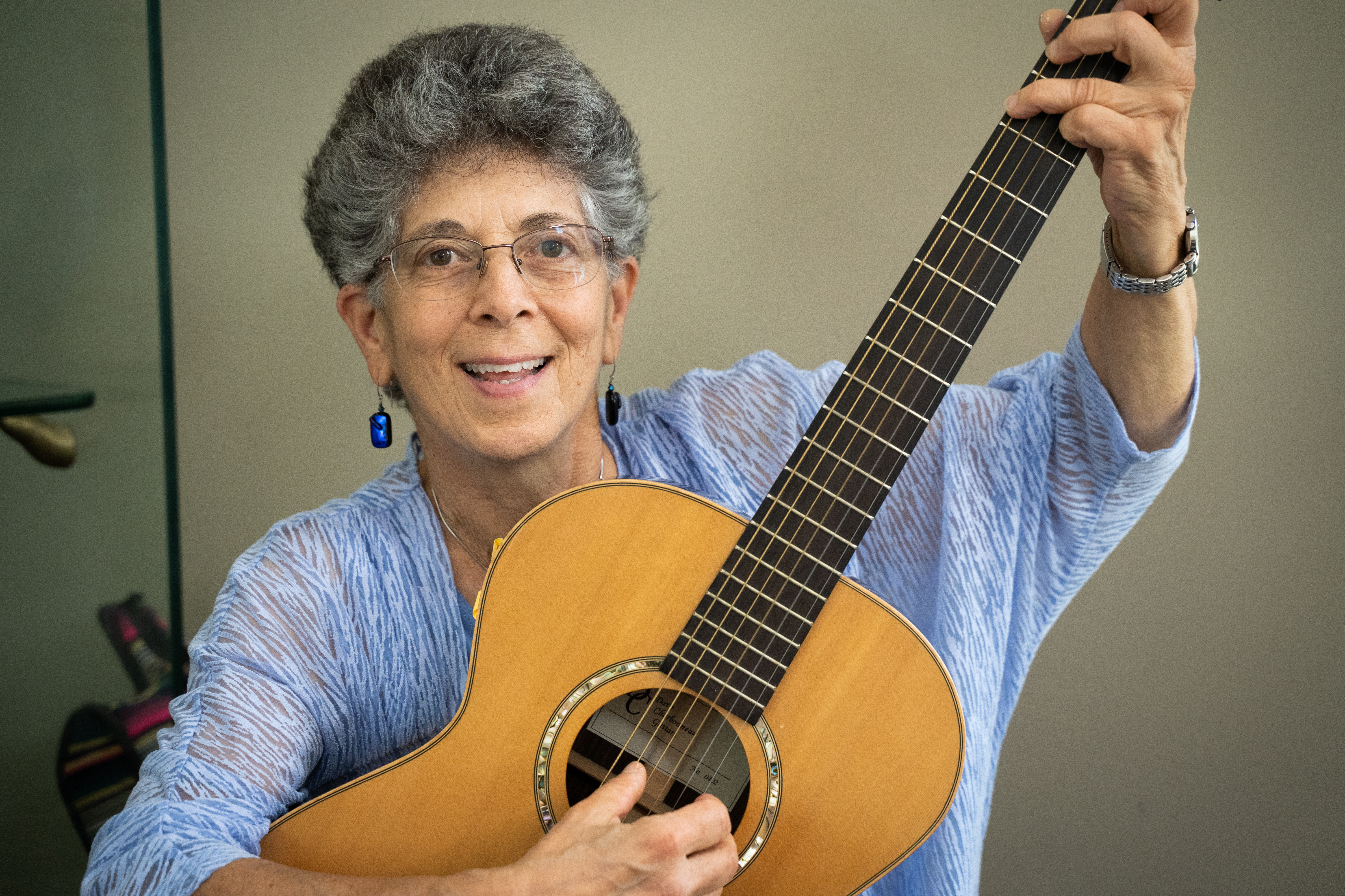 smiling woman with short gray hair raising her arms